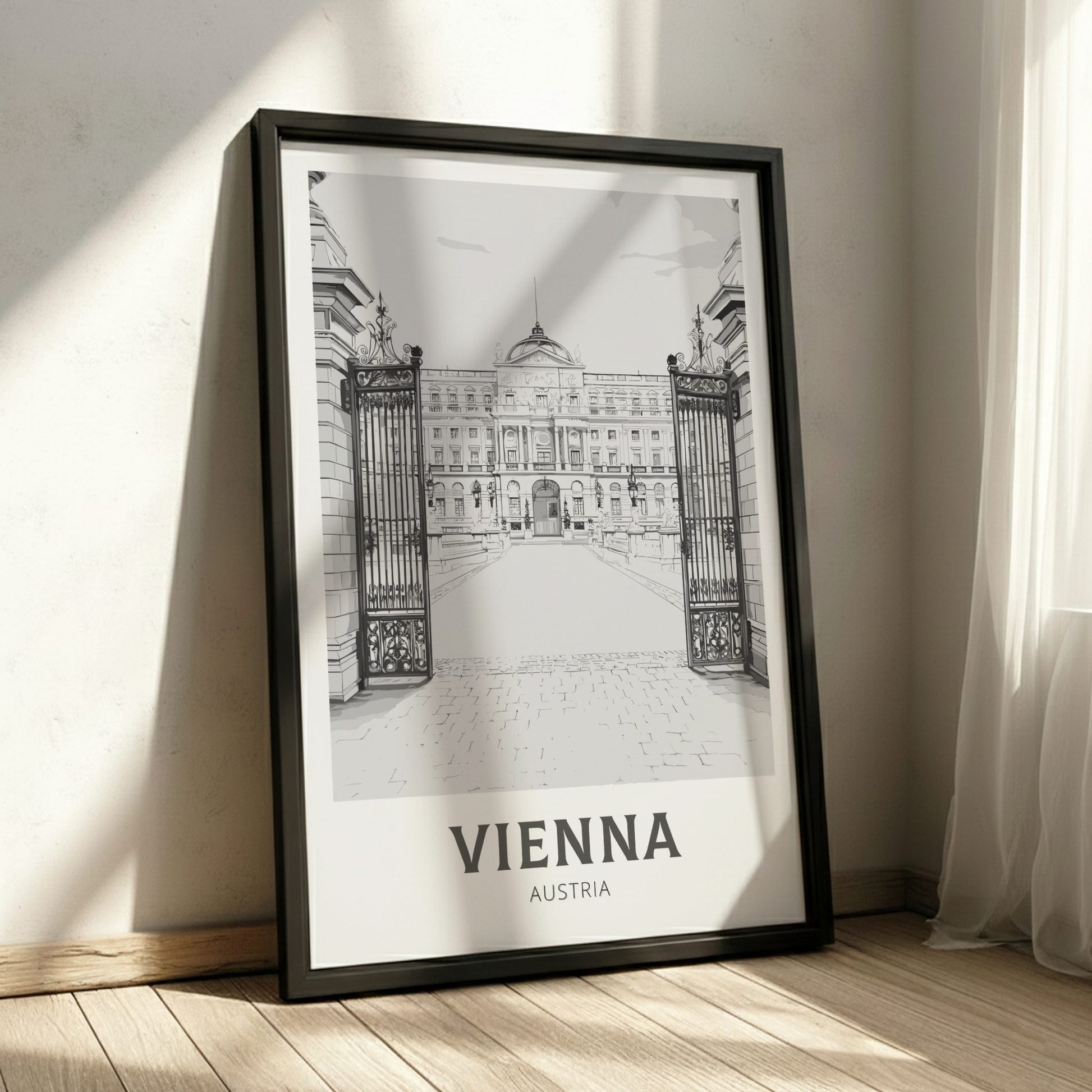 Framed black and white print of a building in Vienna, Austria on a wooden floor.