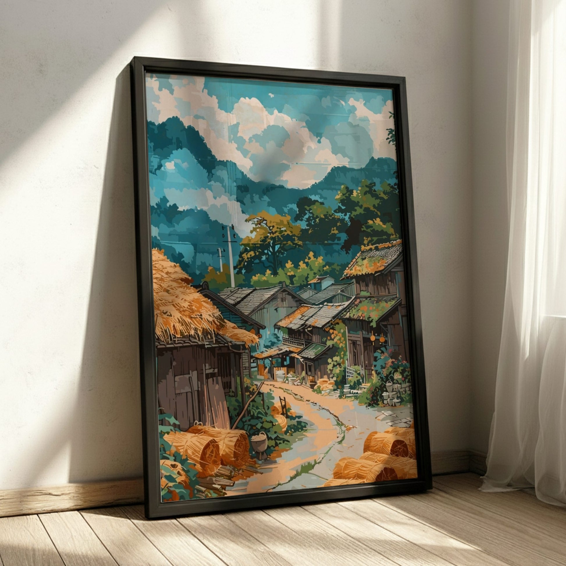 Framed artwork of a village scene with mountains on a wall.