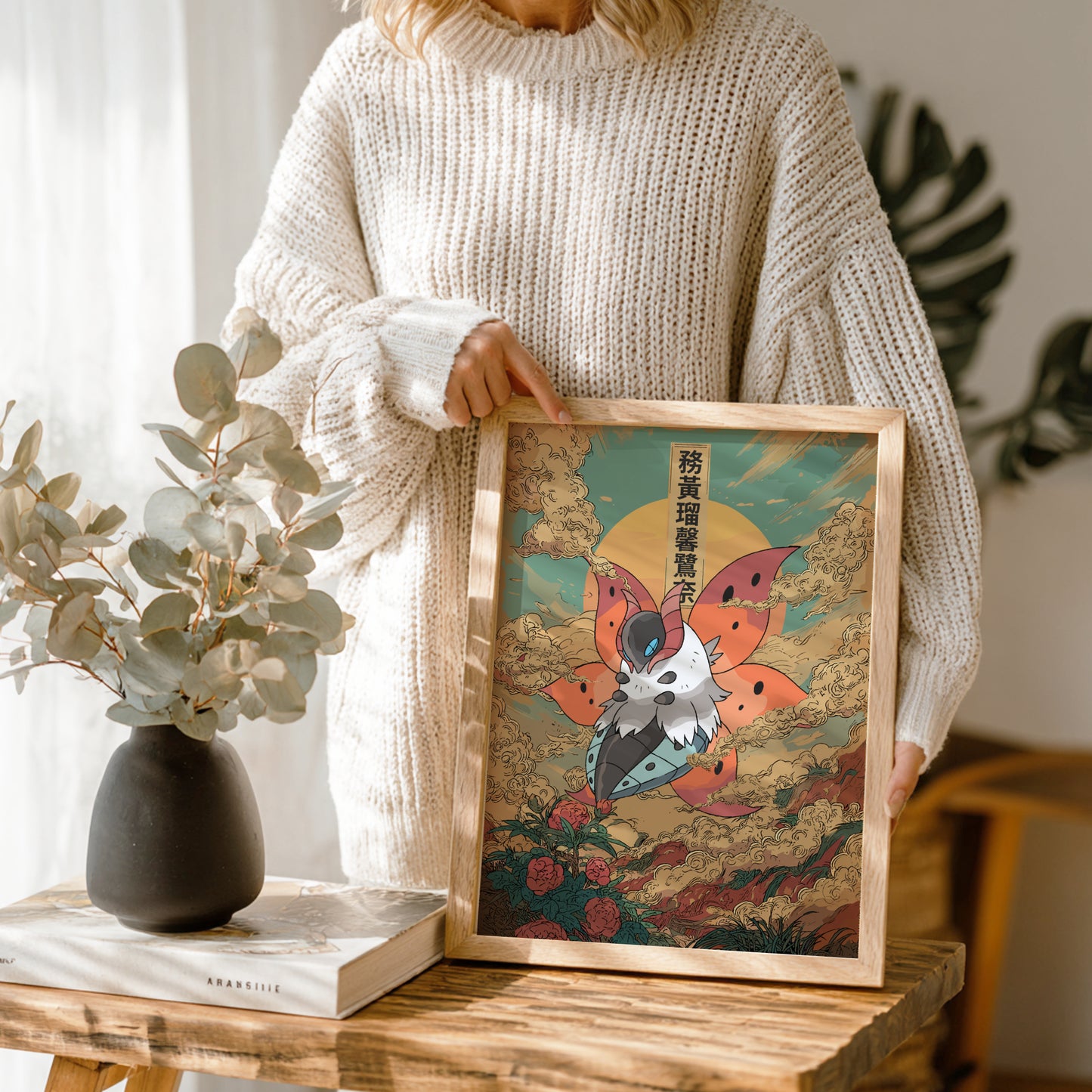 Person holding a framed artwork of Volcarona Pokemon in a home setting
