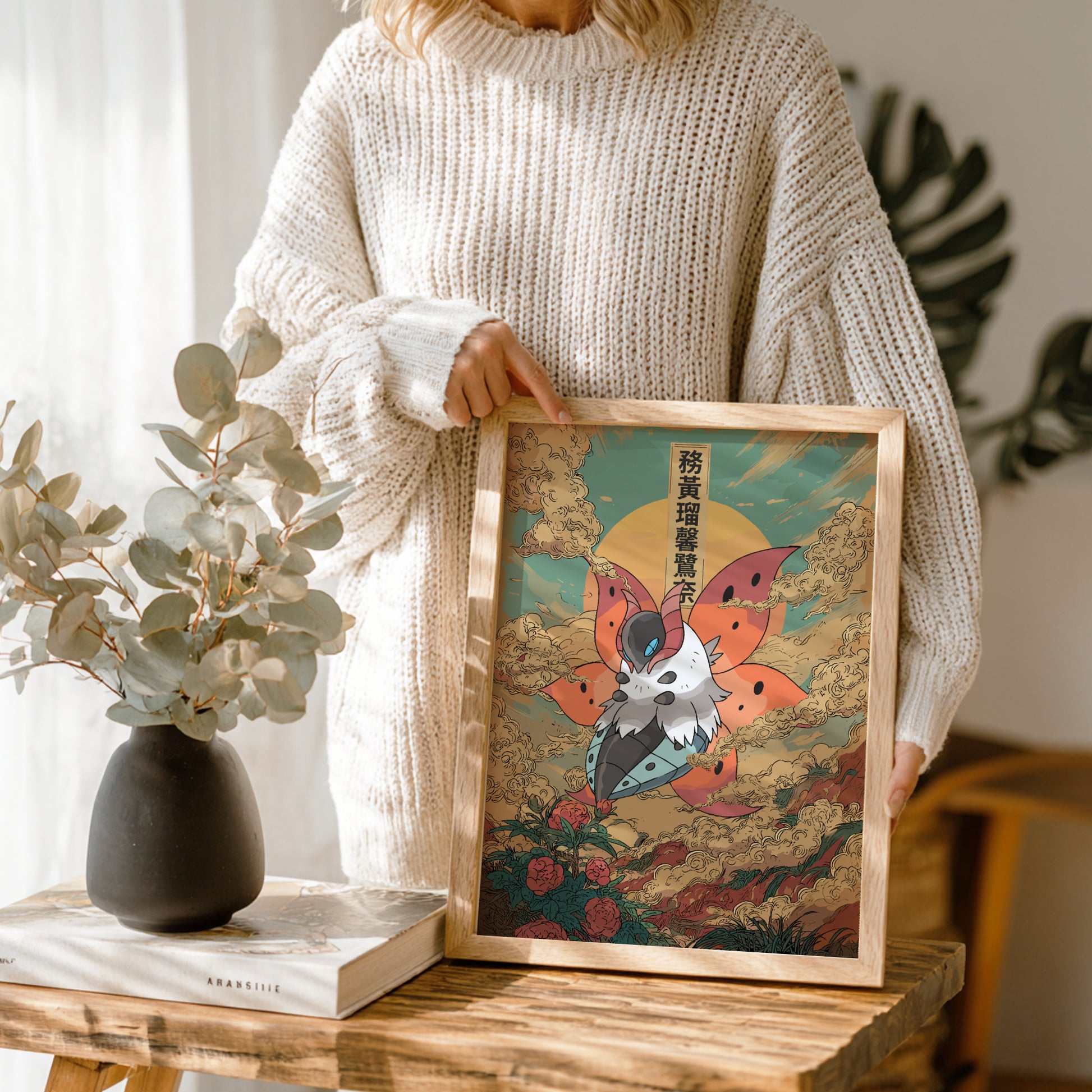 Person holding a framed artwork of Volcarona Pokemon in a home setting