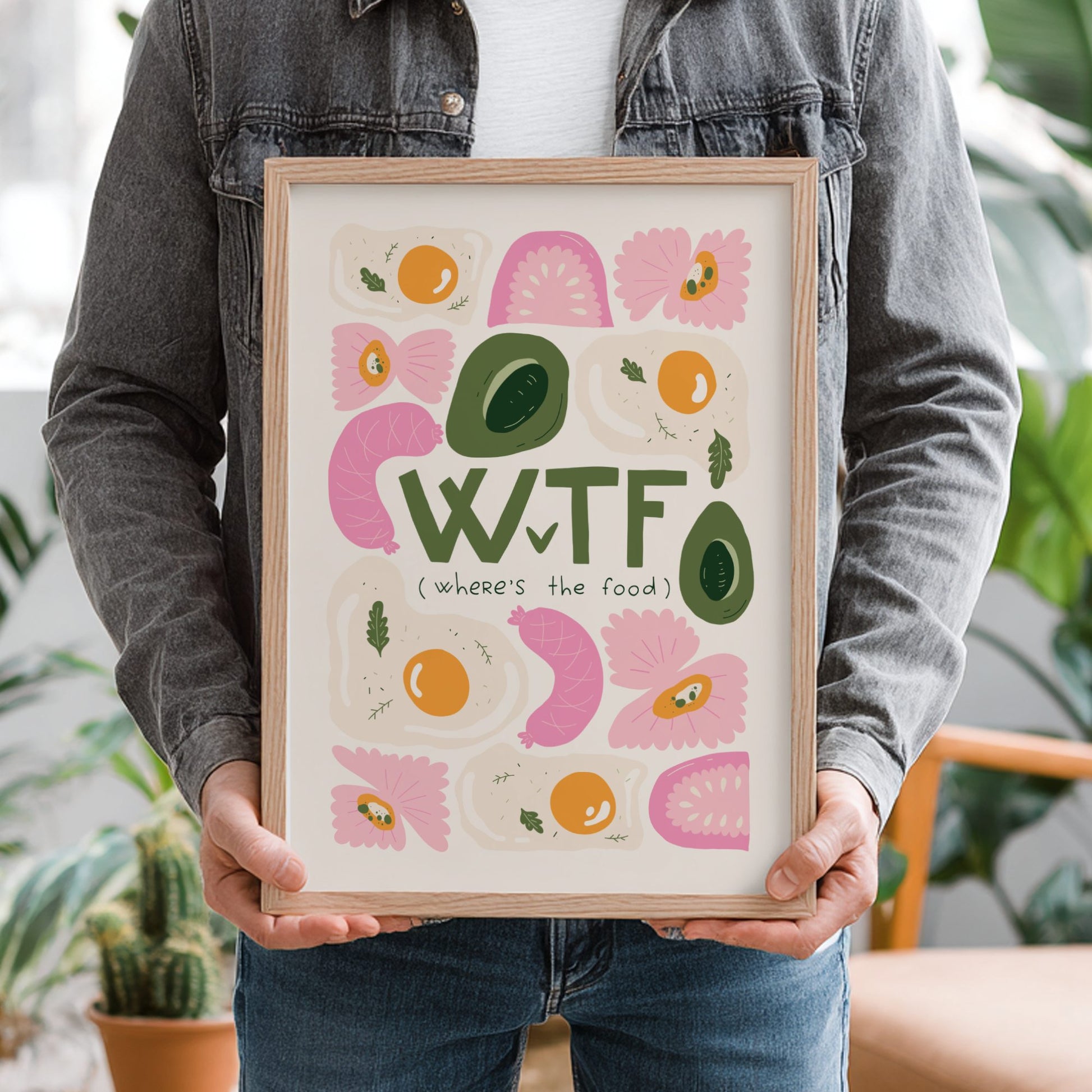 Person holding a framed colorful art print with text and abstract designs.