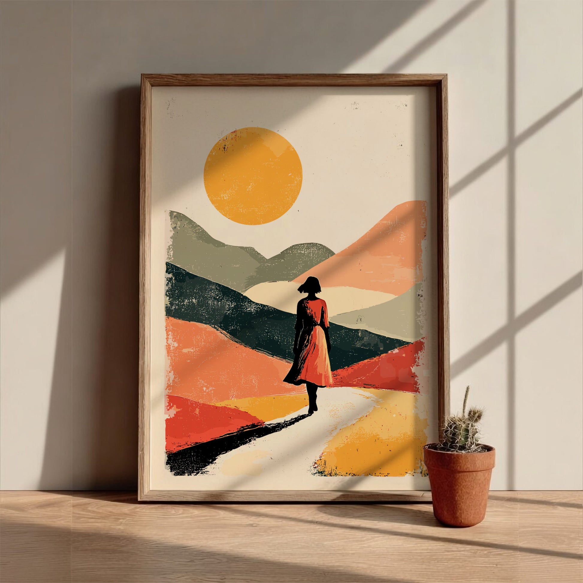 Framed artwork of a person in a dress walking on a path with a colorful landscape and sun.