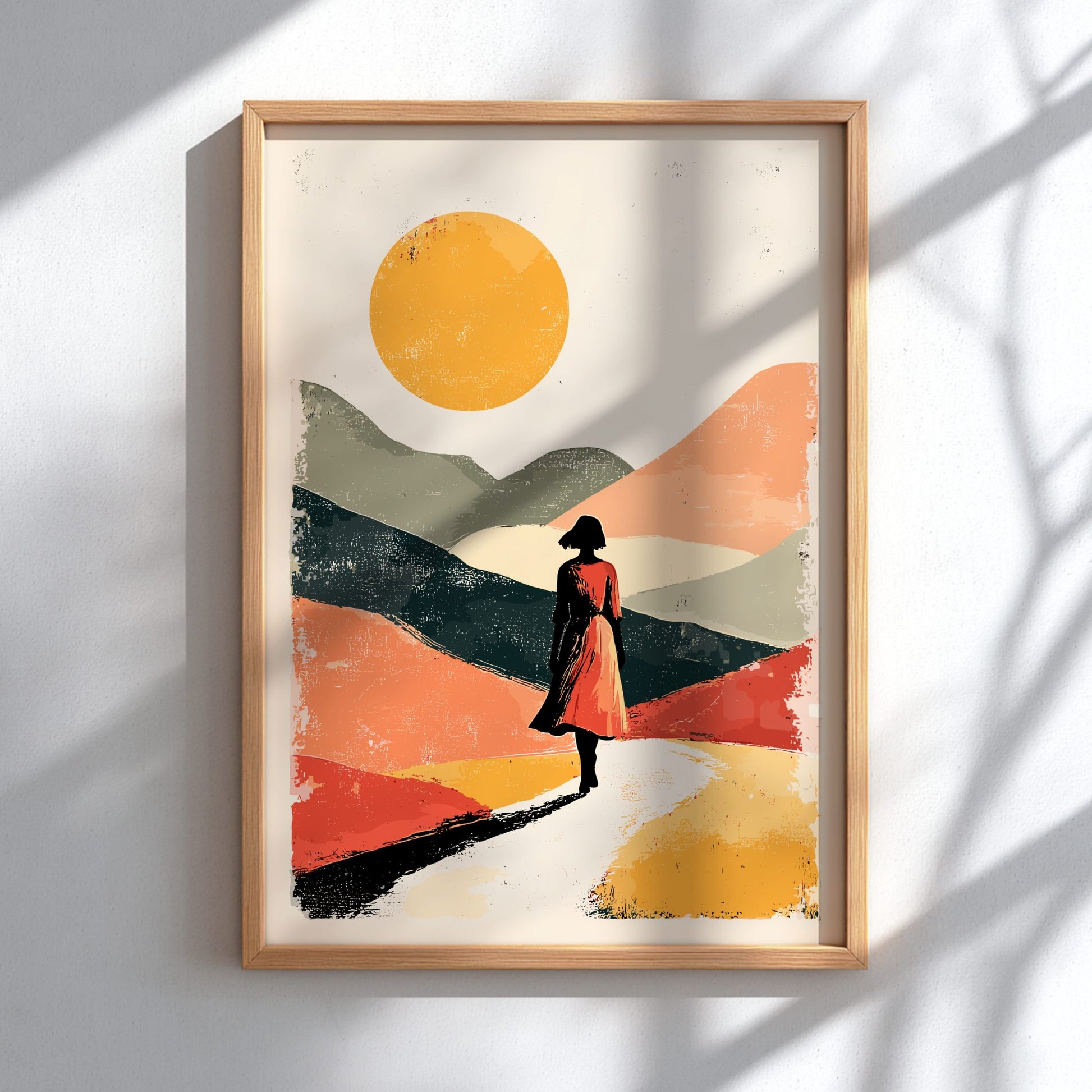 Framed artwork of a silhouette walking on a colorful landscape with a sun.