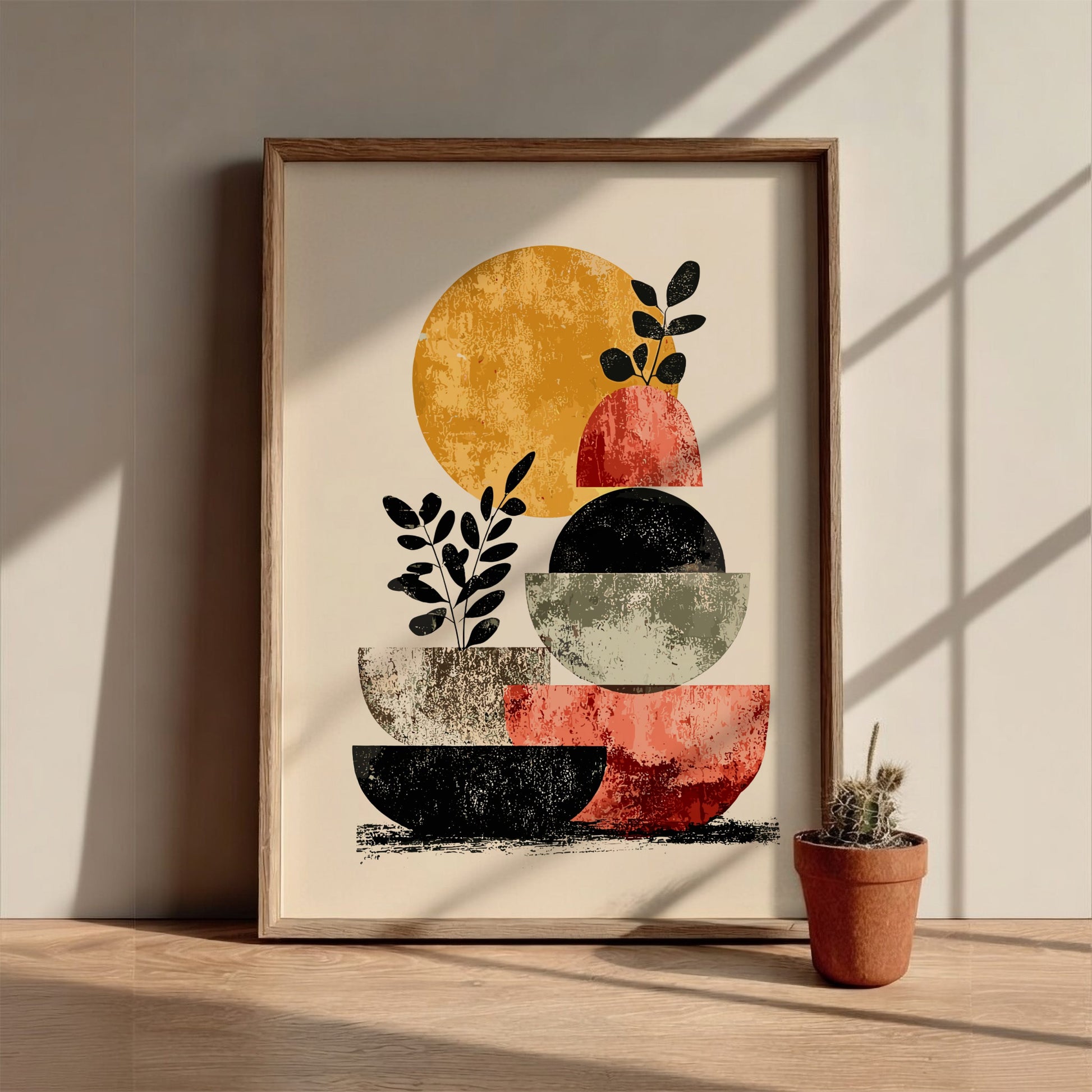 Framed abstract art print with geometric shapes on a wall, accompanied by a small potted plant.