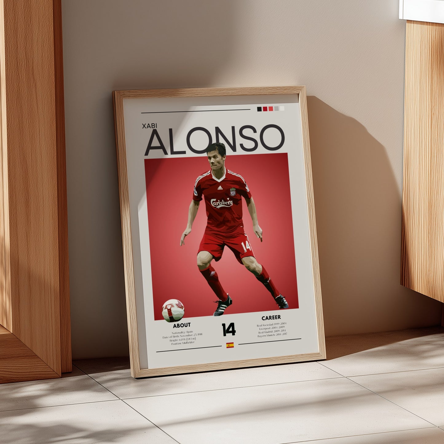 Framed poster of a soccer player in a red uniform on a beige wall.