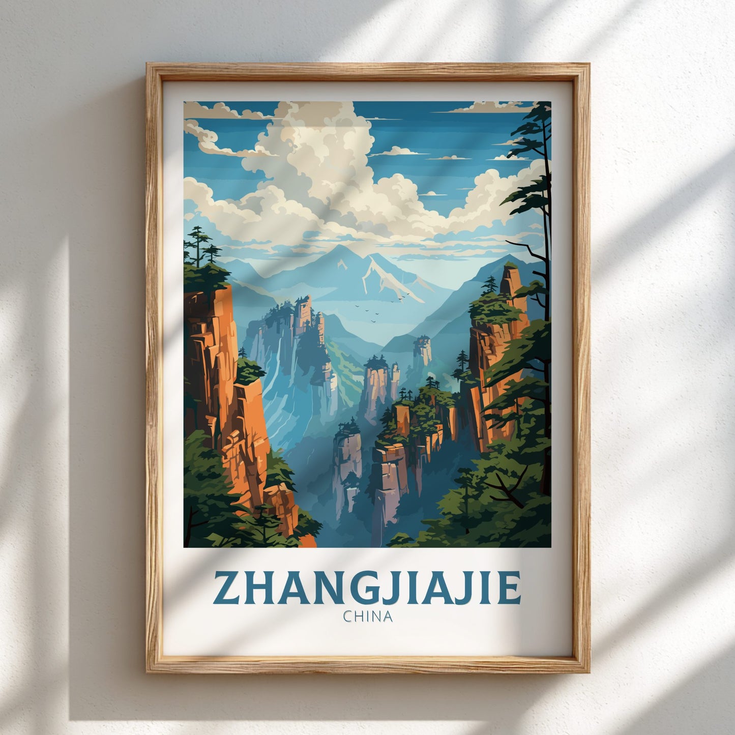 Framed poster of Zhangjiajie landscape with mountains and trees on a white wall.