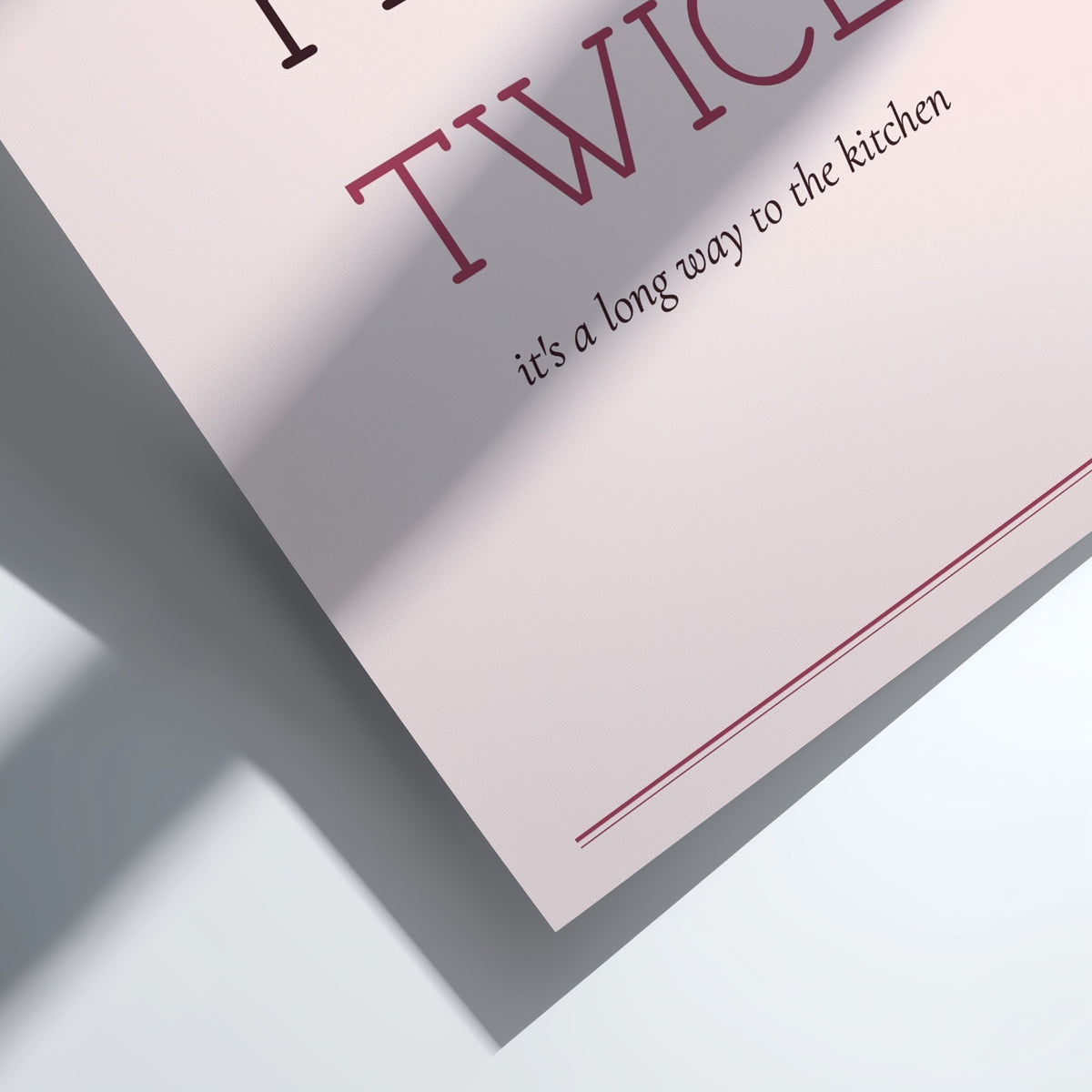 A framed typographic wall art print reading “FLUSH TWICE” with smaller text “it’s a long way to the kitchen,” shown in a light wood frame against a white wall with soft shadow overlays.