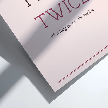 A framed typographic wall art print reading “FLUSH TWICE” with smaller text “it’s a long way to the kitchen,” shown in a light wood frame against a white wall with soft shadow overlays.