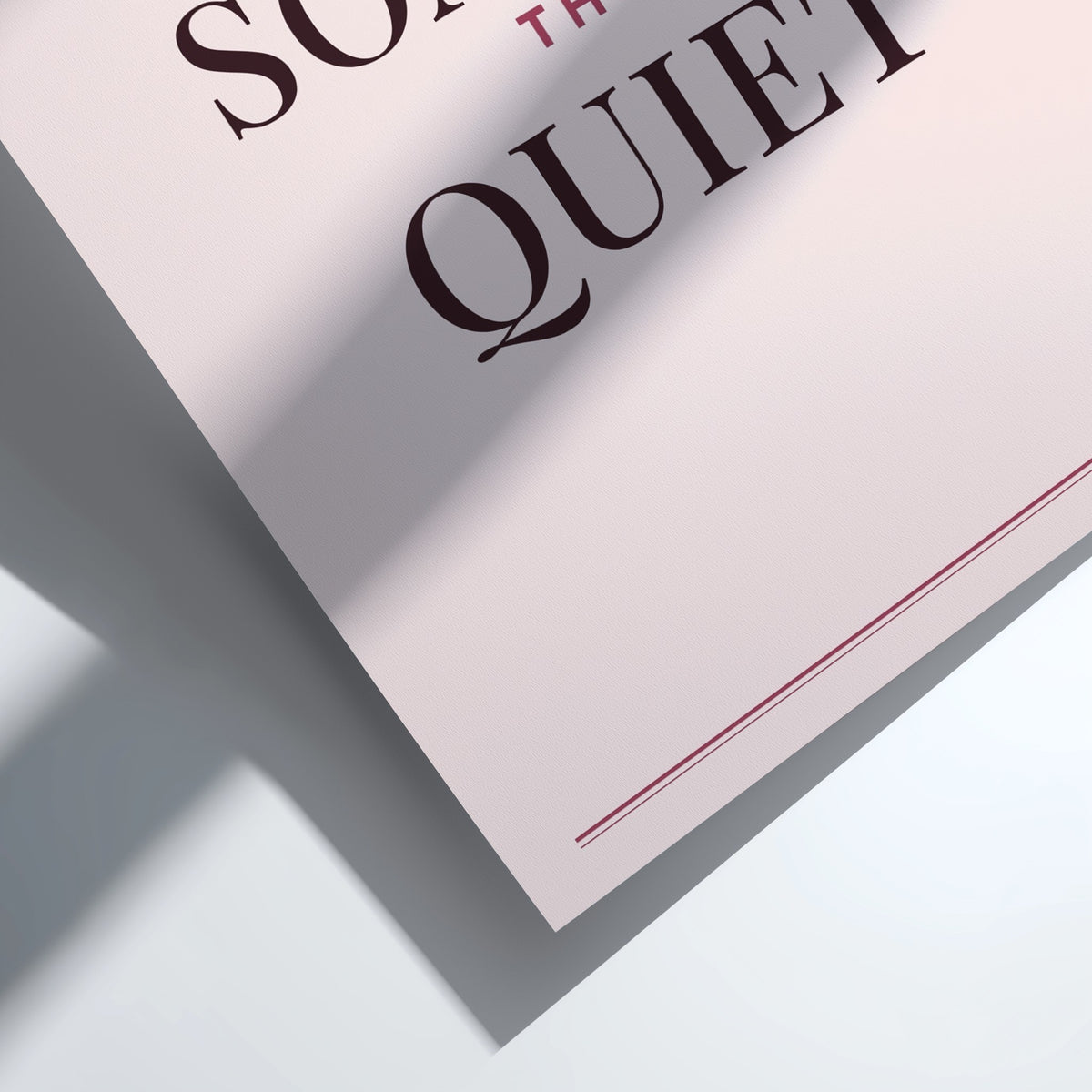 A close-up of a printed sign or poster with the words 'SO Quiet' in dark brown serif lettering on a pale pink background, casting a sharp shadow on a white surface.