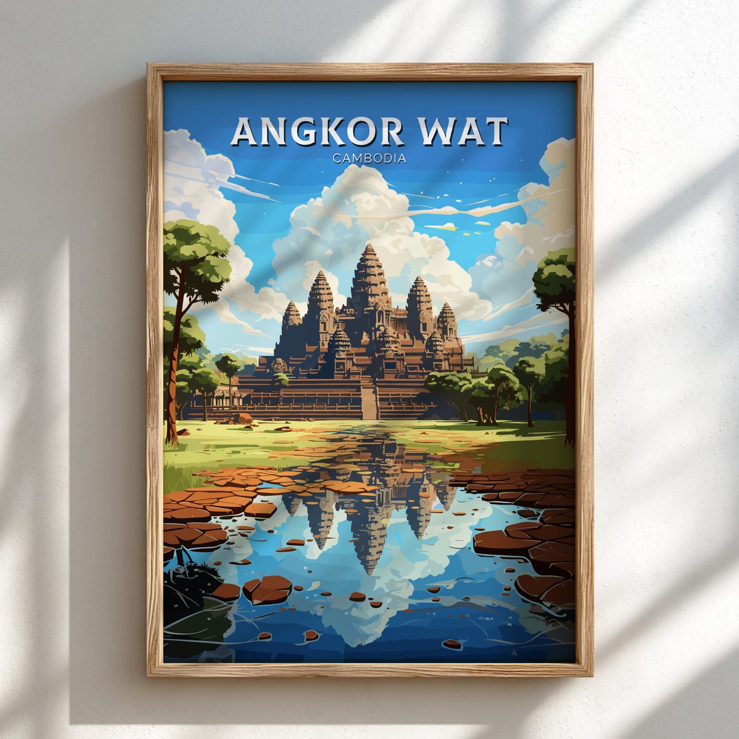 Framed poster of Angkor Wat with a wooden frame on a white wall.