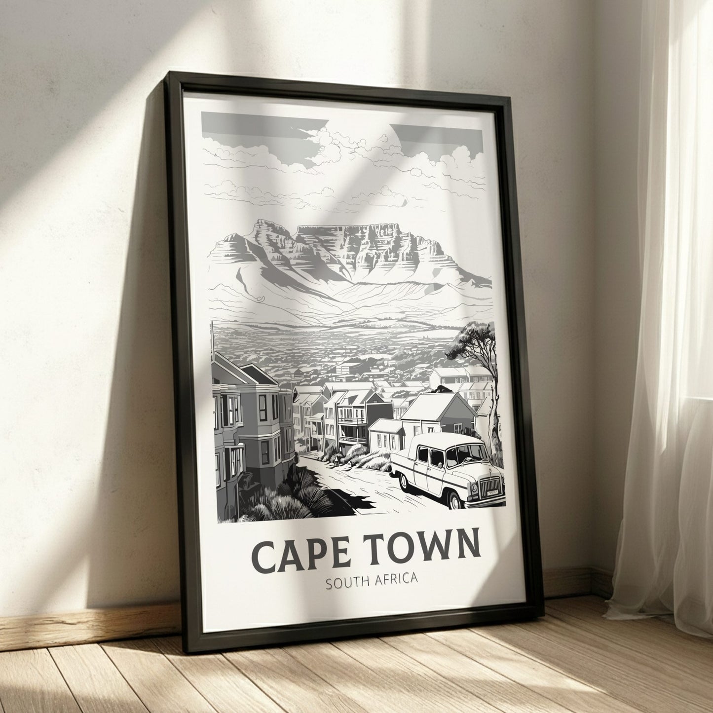 Framed black and white print of Cape Town, South Africa on a wall.