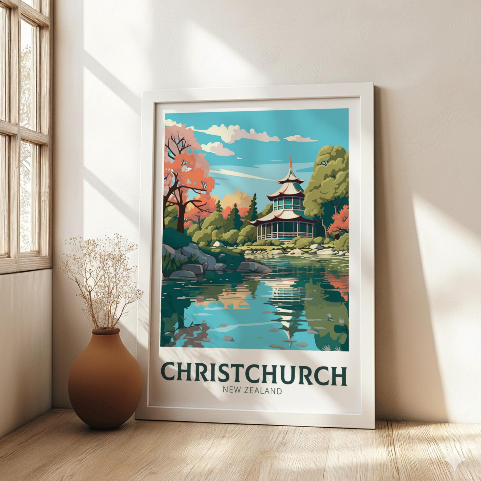 Framed artwork of Christchurch, New Zealand with a pagoda and lake, on a wall in a bright room.