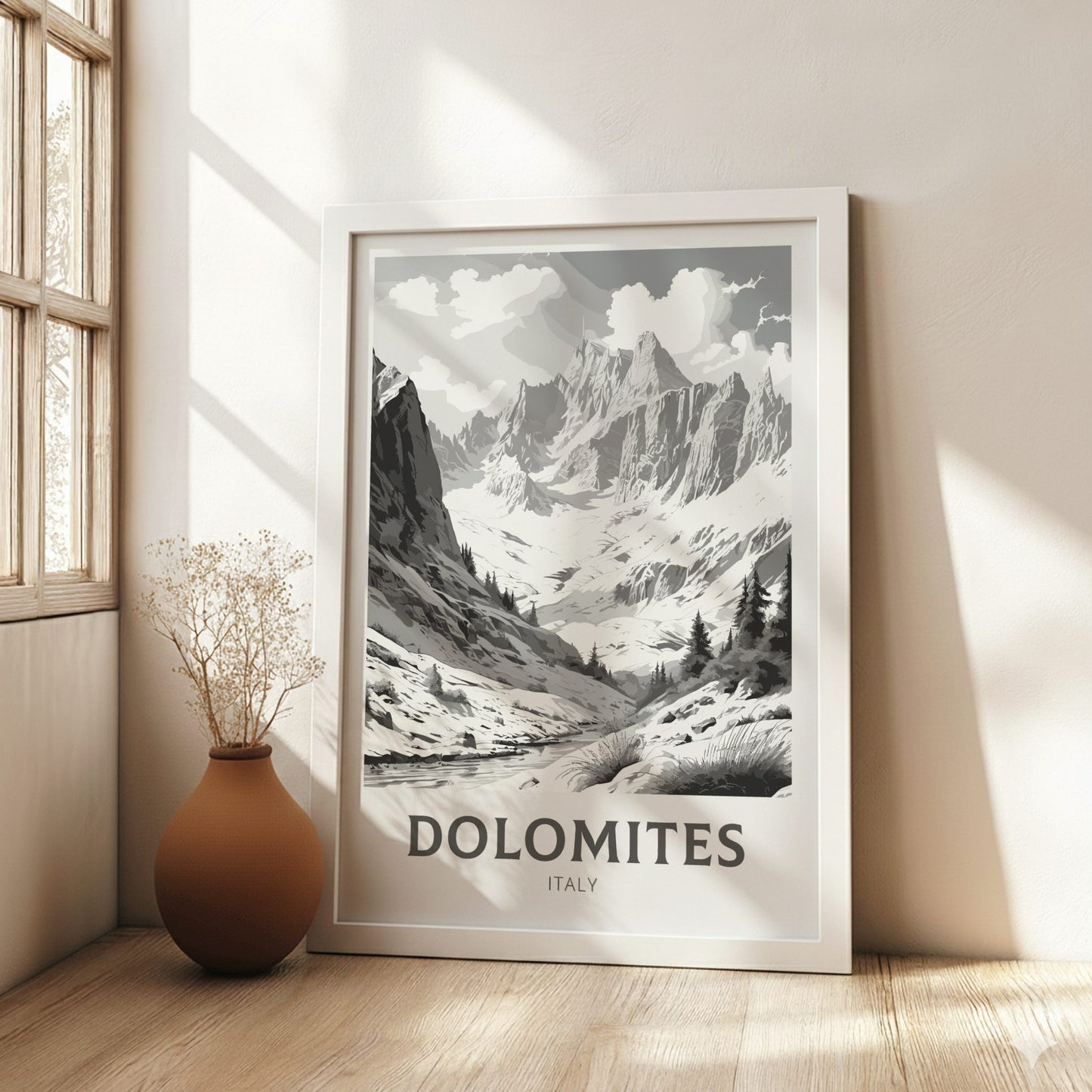 Framed poster of the Dolomites mountains in a room with a vase on a wooden floor.