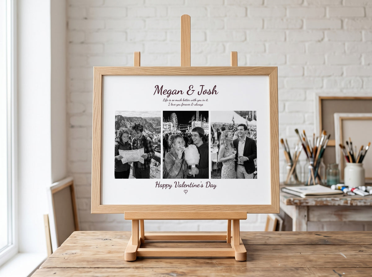 A personalized wooden photo frame displayed on a small easel on a wooden table in a bright, modern studio with a white brick wall background. The frame contains three black-and-white wedding photos with custom text reading 'Megan & Josh' and 'Happy Valentine's Day'.