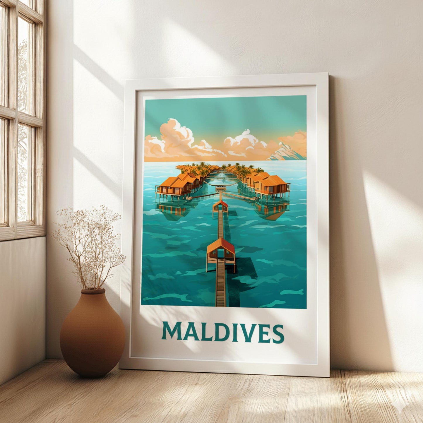 Framed poster of the Maldives with a houseboat scene on a wall in a bright room.