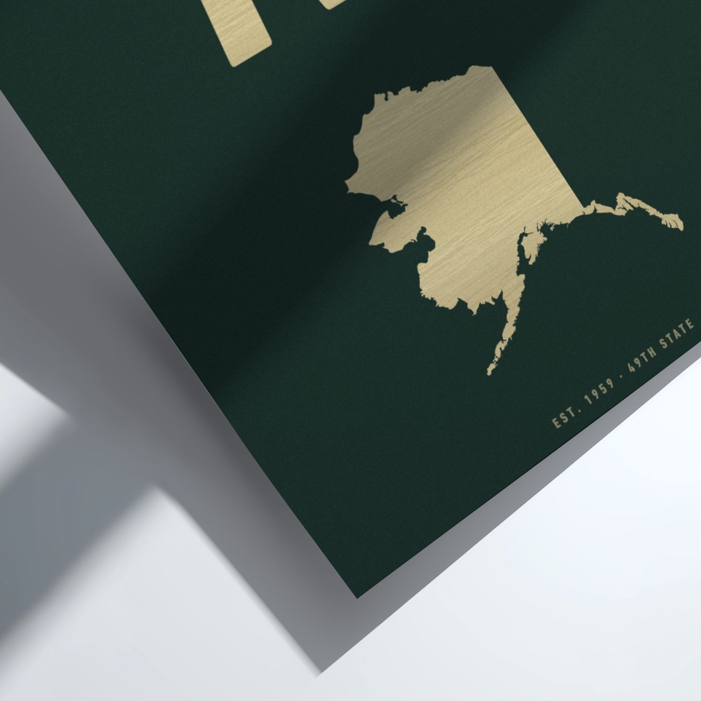 Gold map of Alaska on a dark green background