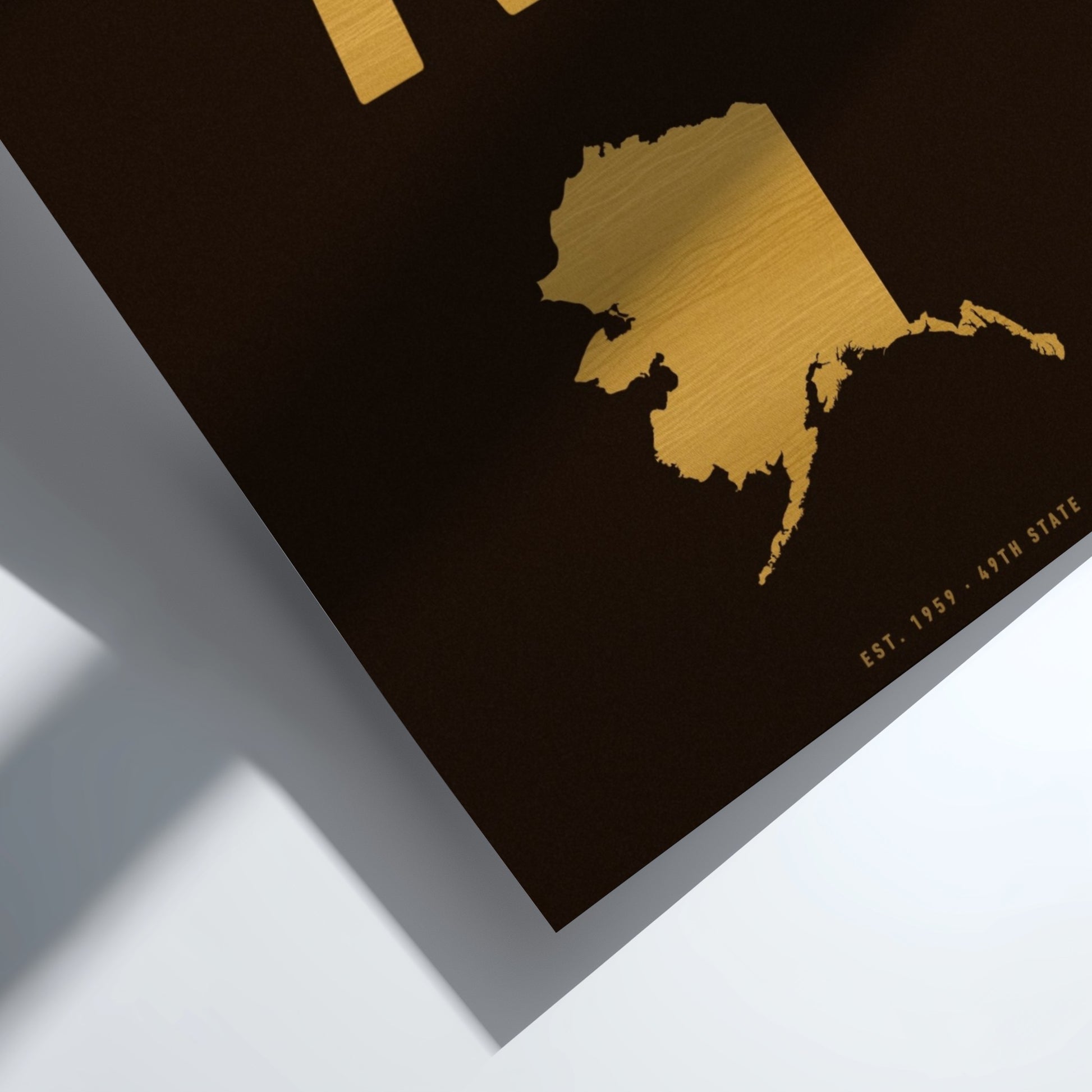 Gold map of Alaska on a black background