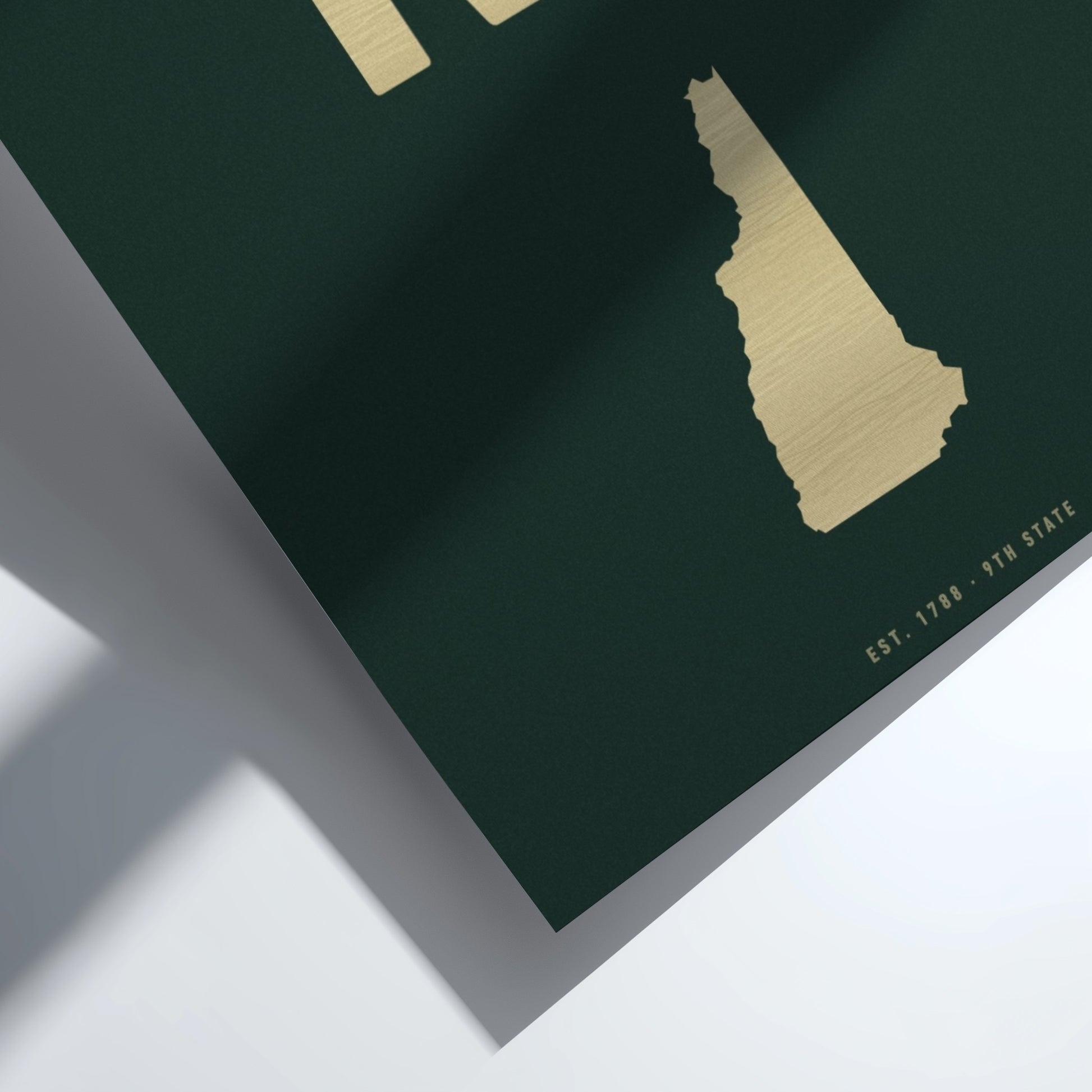 Gold map of New Hampshire on a dark green background