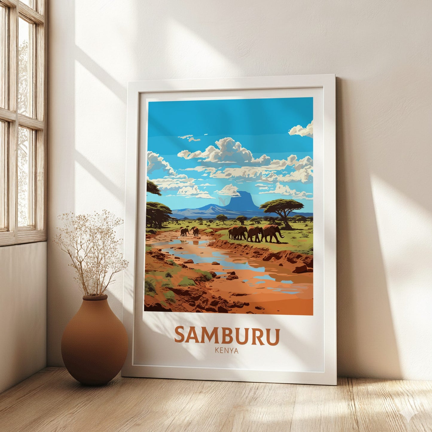 Framed artwork of Samburu Kenya with elephants and landscape, placed on a wooden floor.