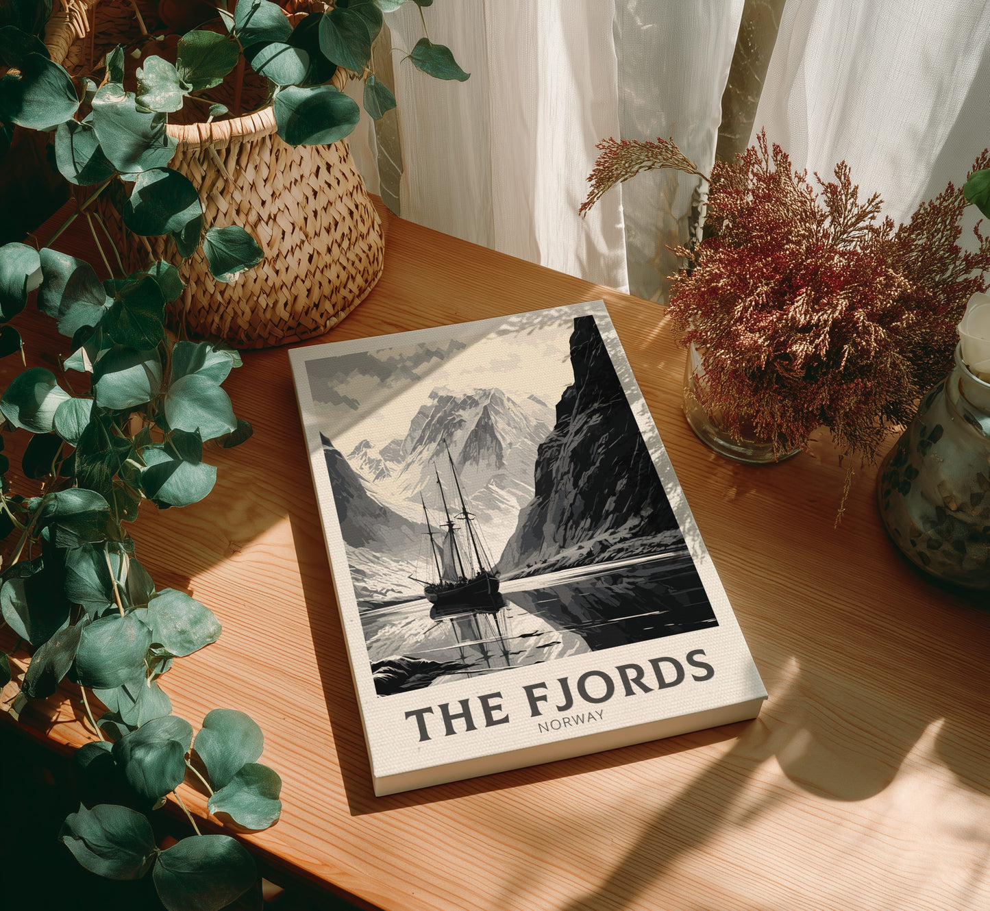Book titled 'The Fjords Norway' on a wooden table with plants around