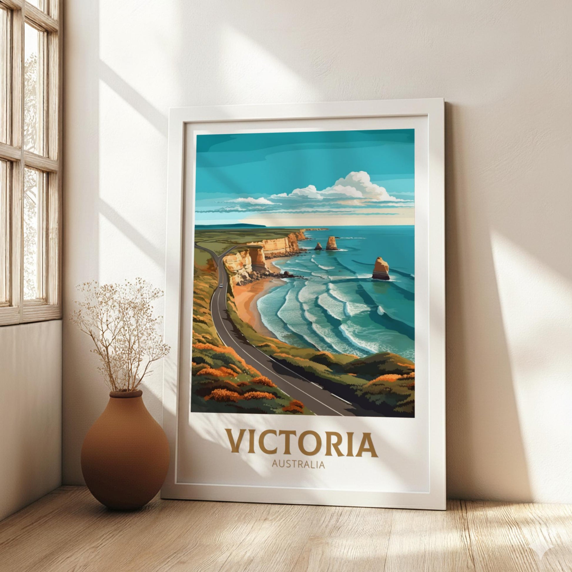 Framed artwork of a scenic view with 'Victoria, Australia' text in a room with a vase and window.